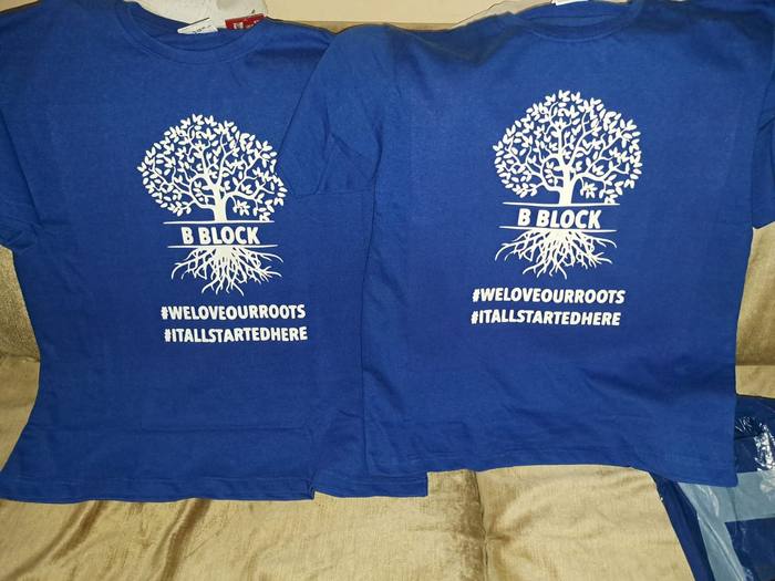 Two royal blue reunion t-shirts printed with a tree and its roots for B Block, hashtagged we love our roots