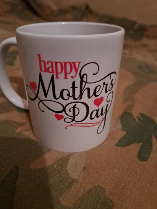 White mug printed Happy Mother's Day in red and black script with hearts