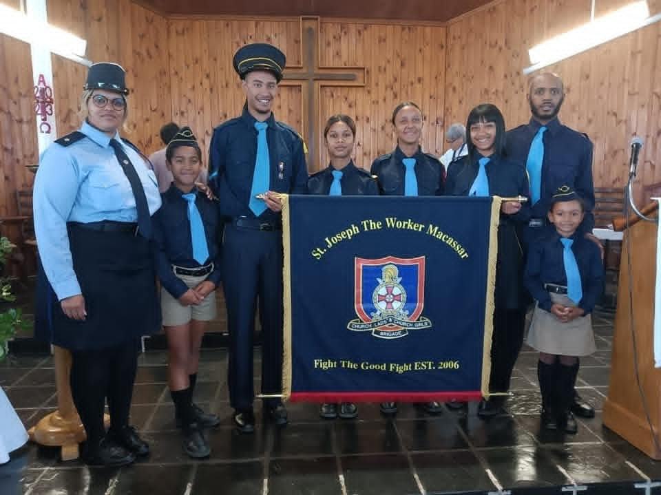 Church Lads and Church Girls Brigade of St Joseph The Worker Macassar in navy uniforms, holding their printed banner